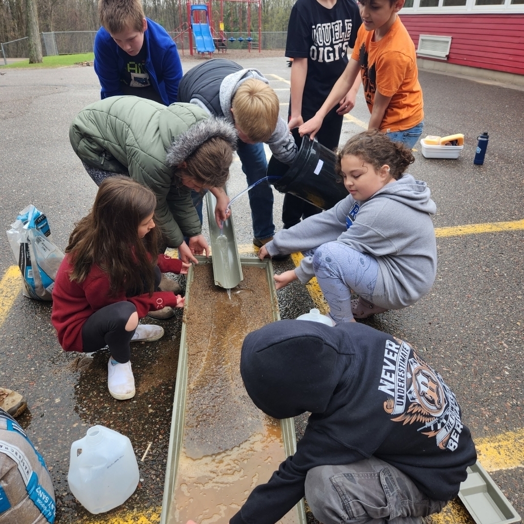 Fifth grade learners observe erosion on the stream table.