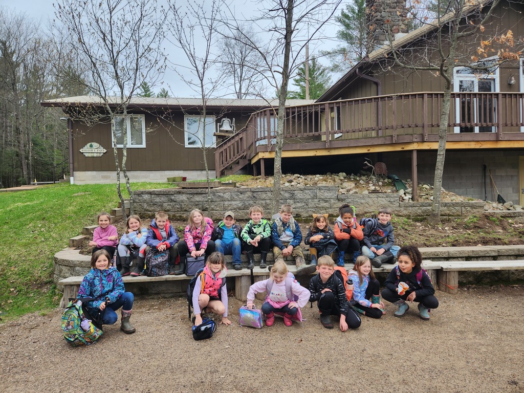 Second grade students gather in front of Merrill School Forest building.