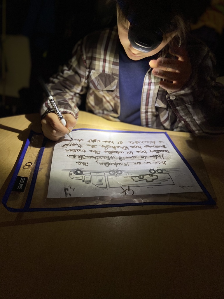 Finishing cursive writing practice with a headlamp.